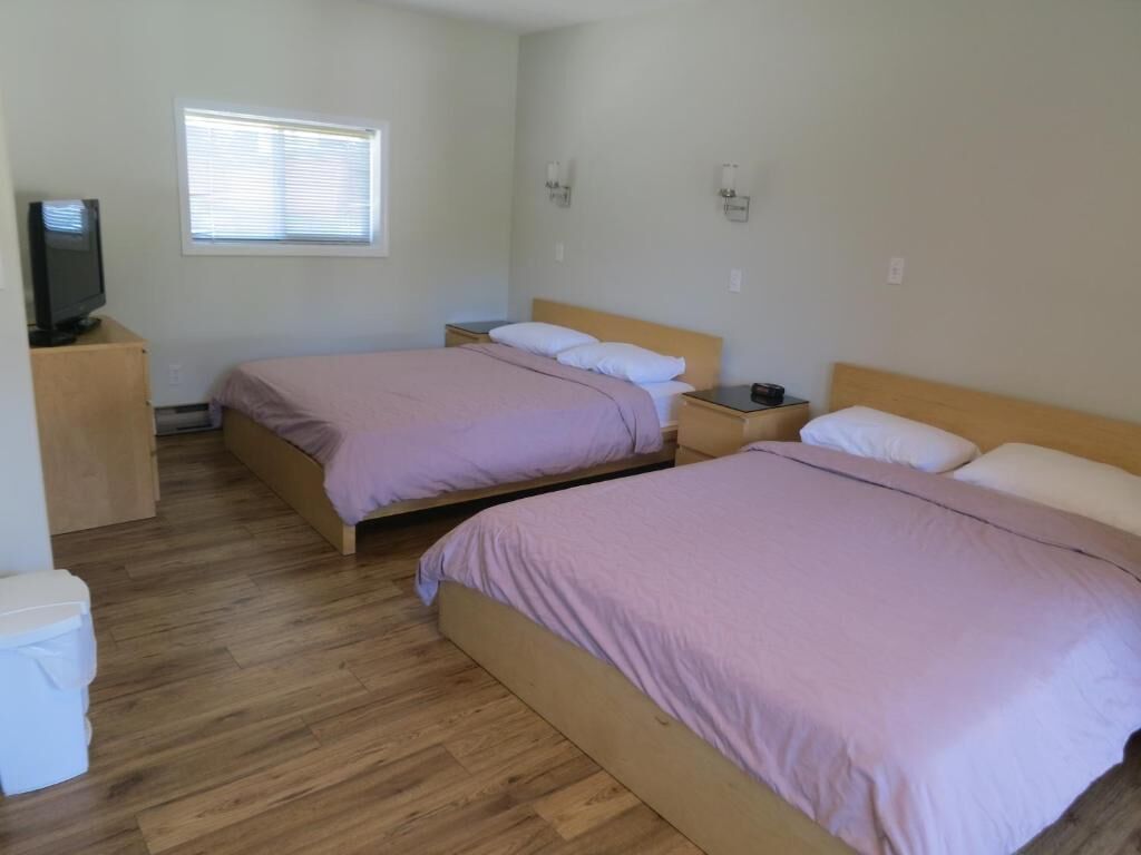 Una habitación con dos camas, televisión y ventana.