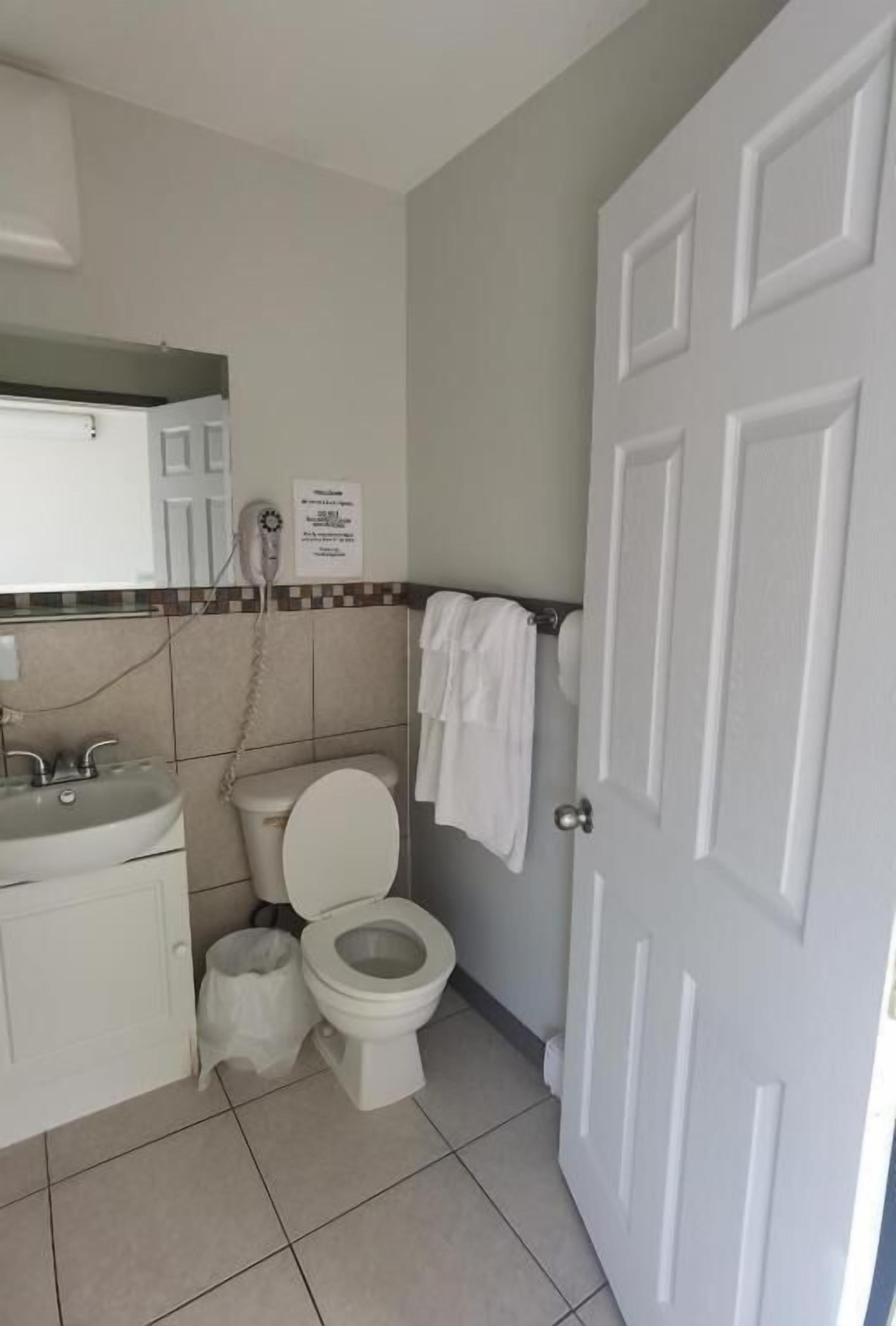 A bathroom with a toilet, sink, and towel rack.