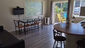 Una cocina moderna con comedor, ventilador de techo y vistas al exterior.