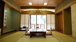 Une pièce de style japonais traditionnel, avec un sol recouvert de tatamis, une table basse et des portes coulissantes.