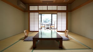 Une pièce de style japonais traditionnel, avec un sol recouvert de tatamis, une basse table en bois et des portes coulissantes en papier de riz (shoji).