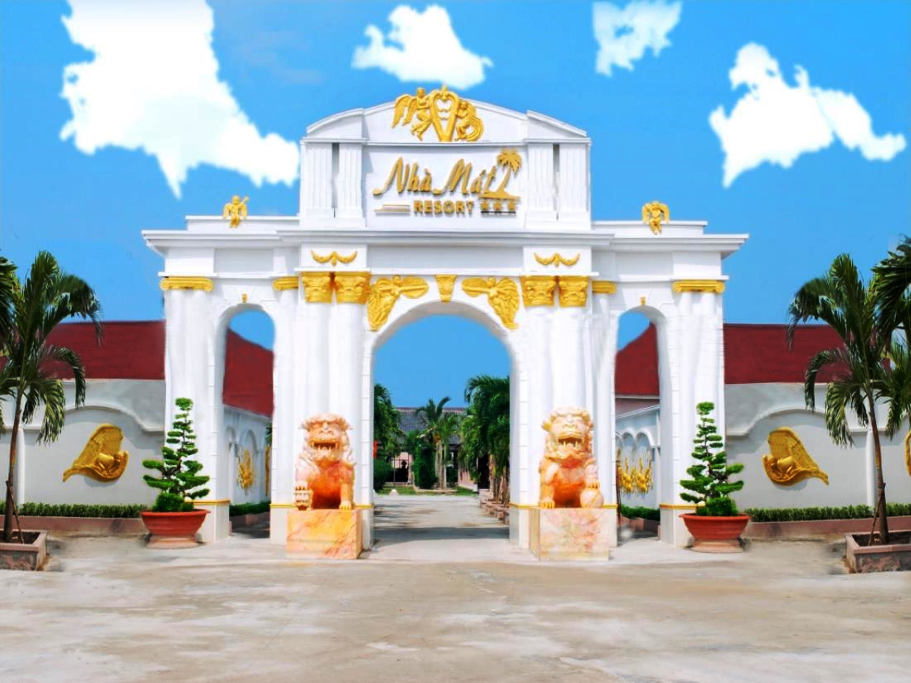 A grand entrance with a white archway, golden lion statues, and the text "Nha Mie Resort".