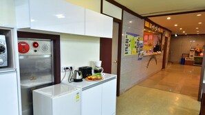 Una cocina compacta equipada con refrigerador, microondas y cafetera.
