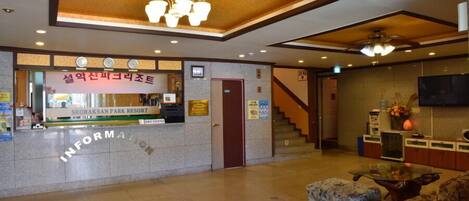 A reception area with a reception desk, a staircase, and seating.