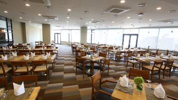 A spacious dining area with multiple tables and chairs, arranged in a grid pattern.