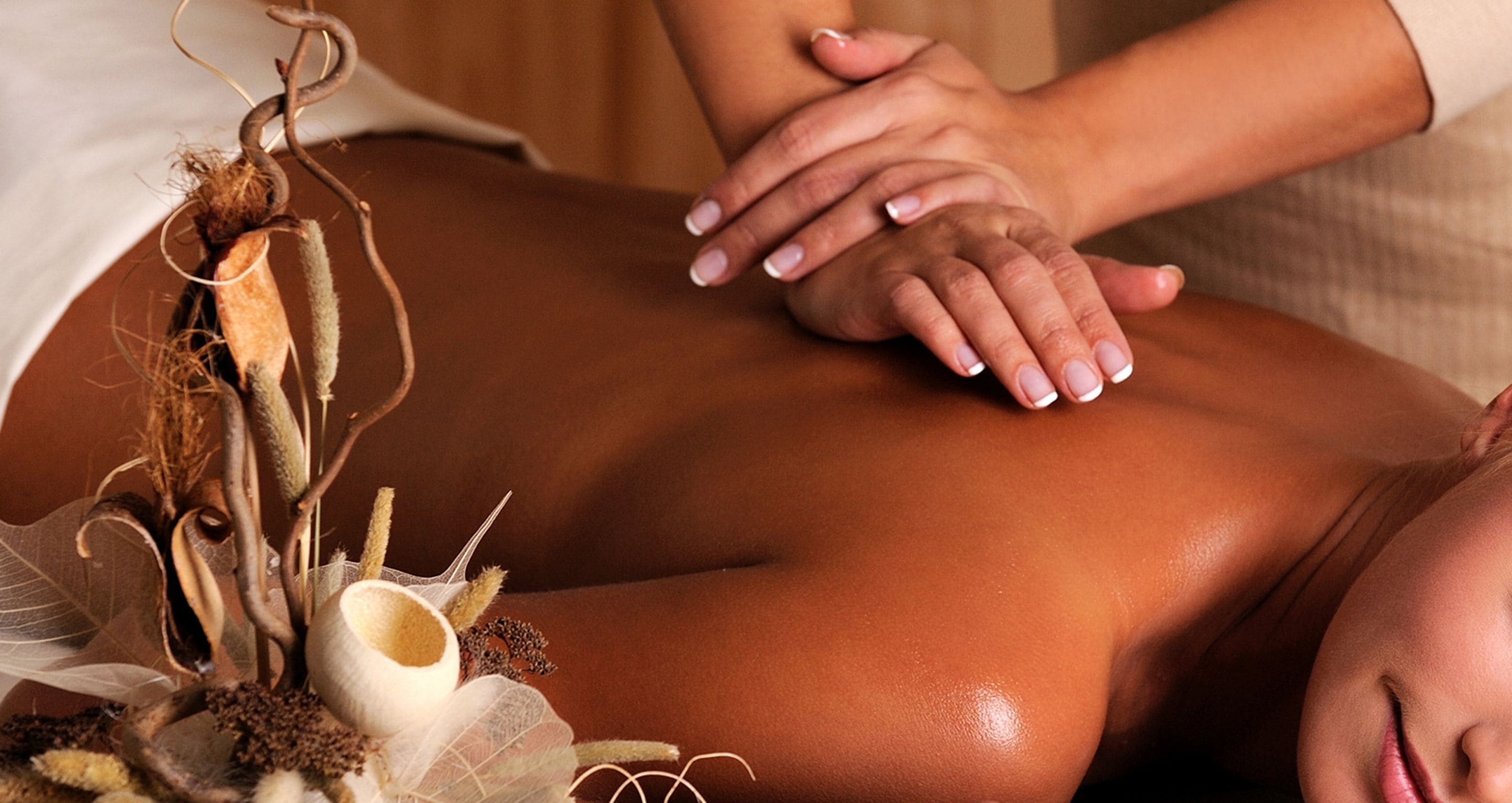 En massagebehandling med fokus på massørens hænder og klientens ryg.