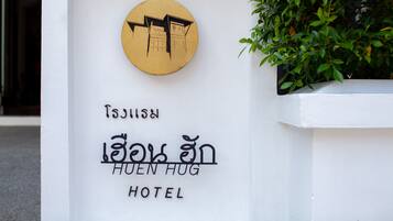 A hotel sign with a circular emblem and bilingual text indicating the hotel name.