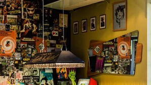 A pool table with a green pool cue, surrounded by various posters and memorabilia on the walls. - Darlo Bar Darlinghurst (Darlinghurst)