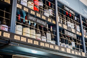 A wine rack with various bottles labeled with names and prices. - Darlo Bar Darlinghurst (Darlinghurst)