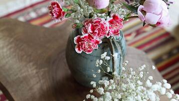 Una mesa de madera con un jarrón de flores rosas y blancas.