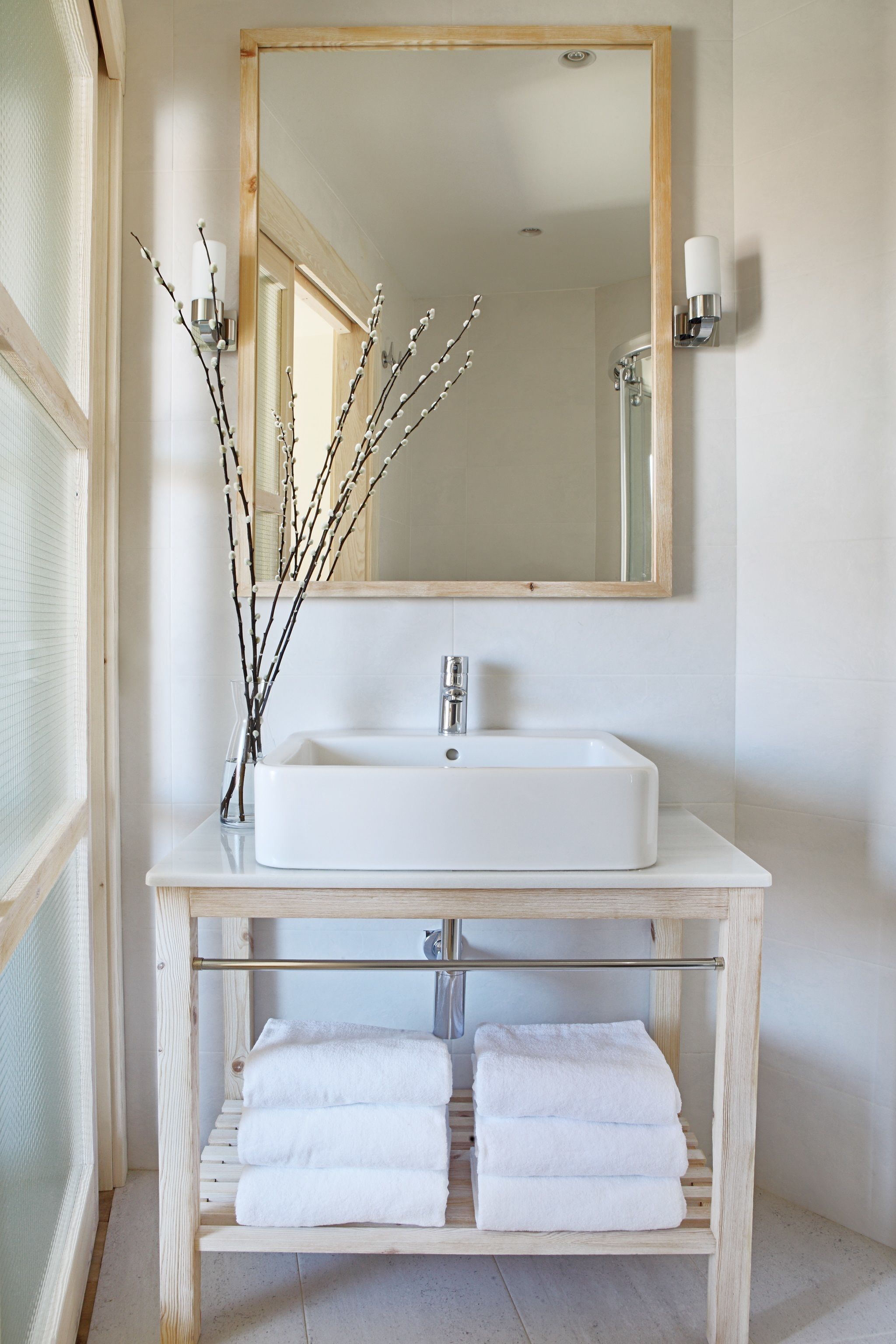 A bathroom with a white sink, a mirror, and a towel rack.