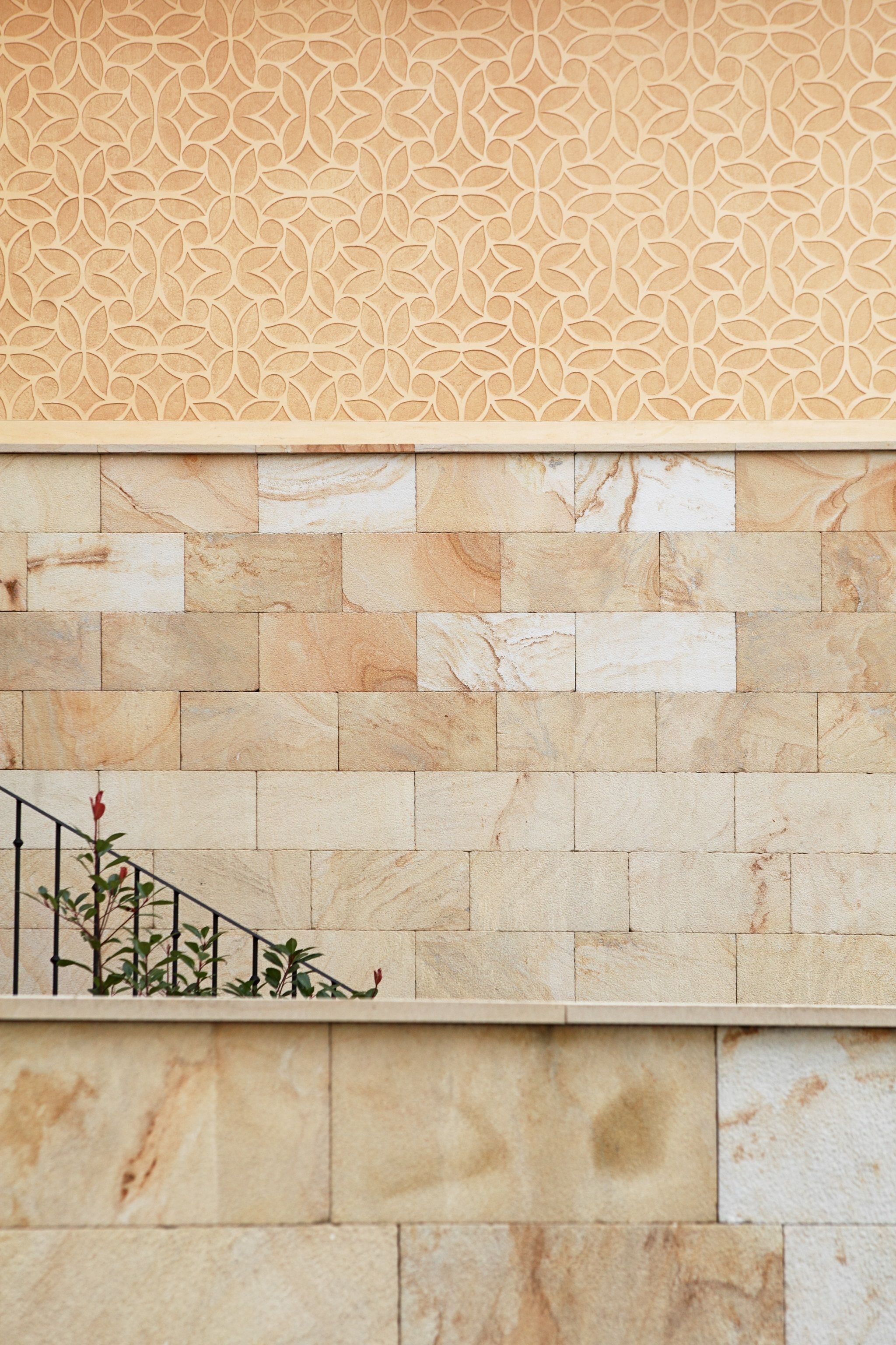 Una pared con diseño ornamental y fachada de piedra.
