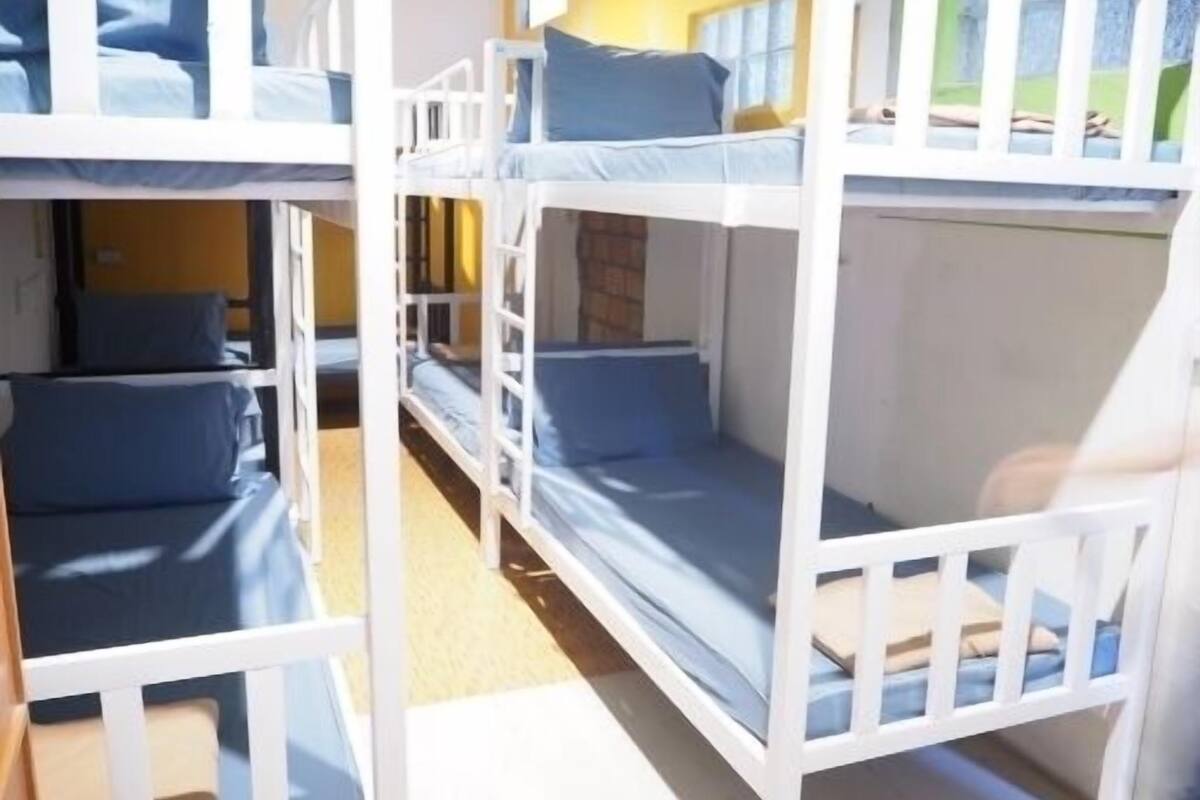 Habitación con literas, dos camas, cada una con ropa de cama azul.