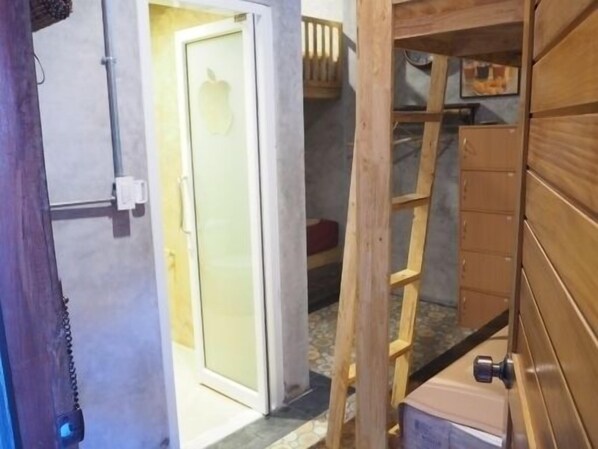A room with a wooden ladder, a door with a frosted glass panel, and a tiled floor.