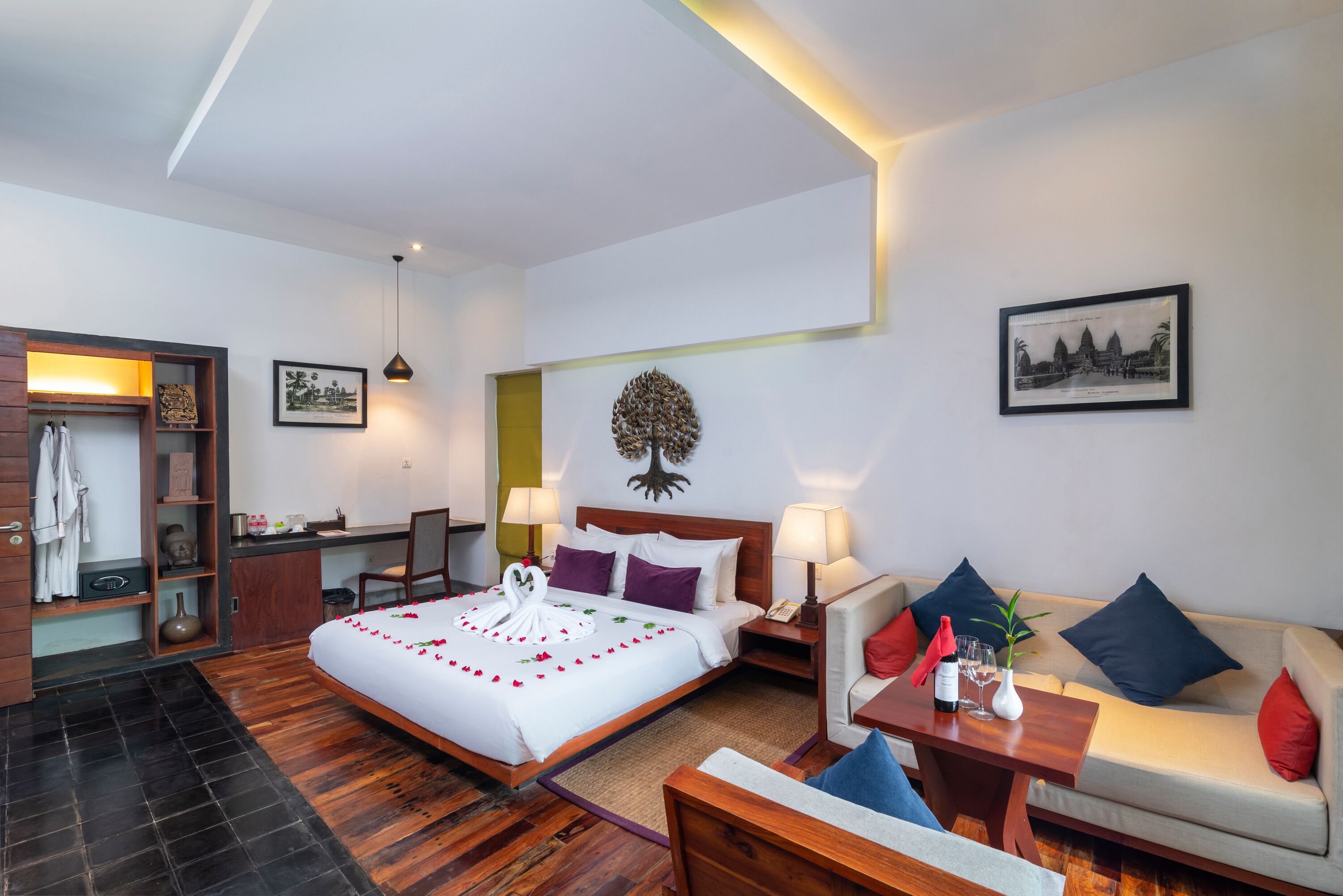 A hotel room with a bed, a sofa, a desk, and a chair.