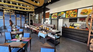 A restaurant with multiple dining tables, a buffet area, and a counter with food and drink options. - King Rock Boutique Hotel (Siem Reap)