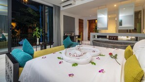 A modern hotel room with a large bed, a sitting area, and a view of the outdoors. - King Rock Boutique Hotel (Siem Reap)