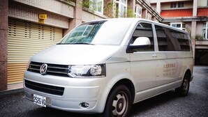 A white van parked in front of a building with a yellow sign displaying the number 603. - Travel Road Hotel (Hualien City)