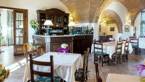 Un restaurante con arcos de ladrillo, mobiliario de madera y una zona de bar.