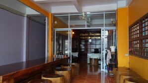 Zona de bar moderna con taburetes de madera y un panel de vidrio.