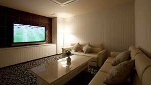 Una sala de estar moderna con una televisión de pantalla plana, un sofá, una mesa de centro y una alfombra estampada.