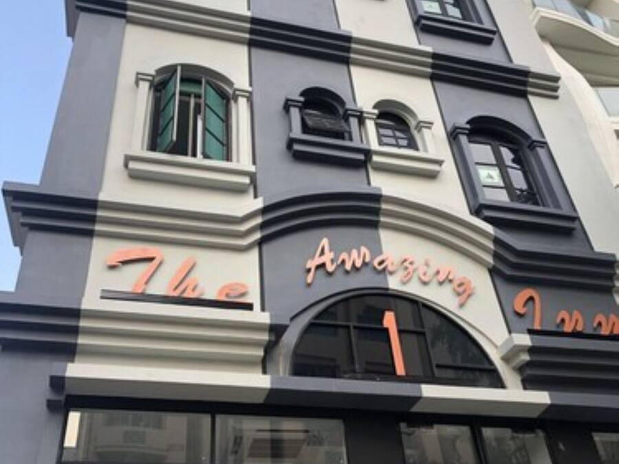 Fachada de hotel con el letrero "The Amazing 1 Inn".