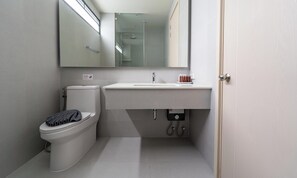 Une salle de bain moderne avec des toilettes, un lavabo et un miroir.
