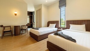 A hotel room with two beds, a desk, and a chair. - The Regent Studio Kamala (Kamala)