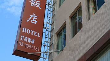 Hotel sign with name in Chinese and English, along with contact information.