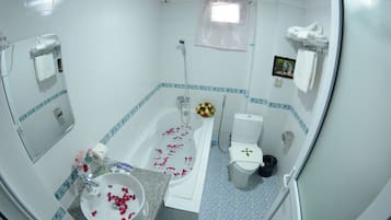 Un baño con bañera, inodoro, lavabo y ducha.