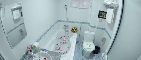 A bathroom with a bathtub, toilet, sink, and a shower.
