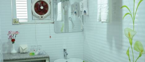 Un baño con inodoro blanco, lavabo y ducha.