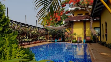 Alberca al aire libre y camastros