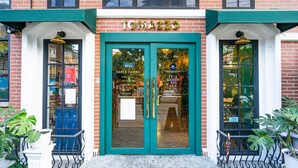A building with a green awning and the name "TOMAZZO" above the entrance.