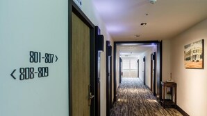 A hotel hallway with directional signs, a patterned carpet, and a framed picture on the wall. - 53 Hotel (Taichung)