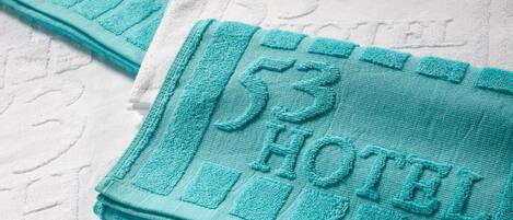 A stack of folded towels with a hotel logo and the number 53.