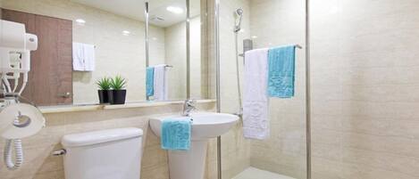 A modern bathroom with a toilet, sink, and shower area.