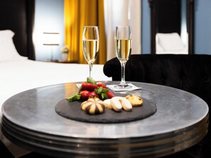 A round table with two glasses of white wine, strawberries, and cookies. - Jb Relais - Campo De' Fiori (Rome)