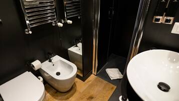 Une salle de bain moderne équipée d’un bidet, de toilettes et d’un lavabo.