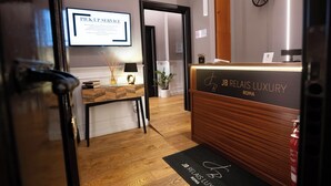 Un comptoir d’accueil avec une enseigne indiquant : « JB RELAIS LUXURY ROMA ».