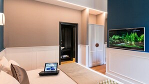 Une chambre d’hôtel moderne équipée d’un lit, d’une télévision, d’un bureau avec un ordinateur portable et d’une armoire.