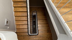 A wooden staircase with a white handrail and a metal door frame. - Green Heart Hostel (Lisbon)
