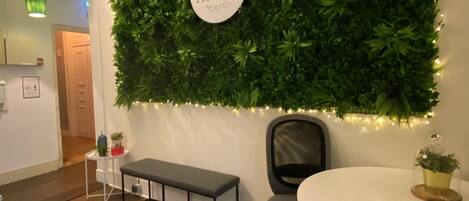 A room with a green wall, a round table, a bench, and a chair.