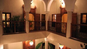 A multi-level interior with arched ceilings and wooden balconies. - Riad Couleurs du Sud (Marrakech)