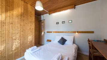 Habitación doble | Escritorio y ropa de cama