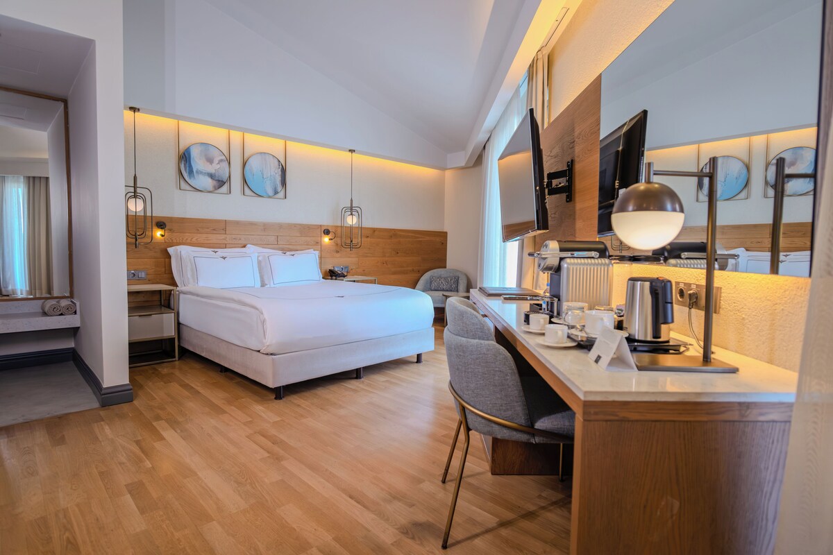 Une chambre d’hôtel équipée d’un lit, d’un bureau, d’une chaise et d’un téléviseur.