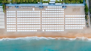 Aan een privéstrand, ligstoelen, parasols, strandlakens