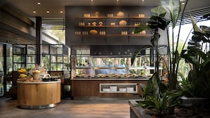 A modern kitchen with a central island, open shelving with kitchenware, and a view of the outdoors. - Miramare Beach Hotel (Manavgat)