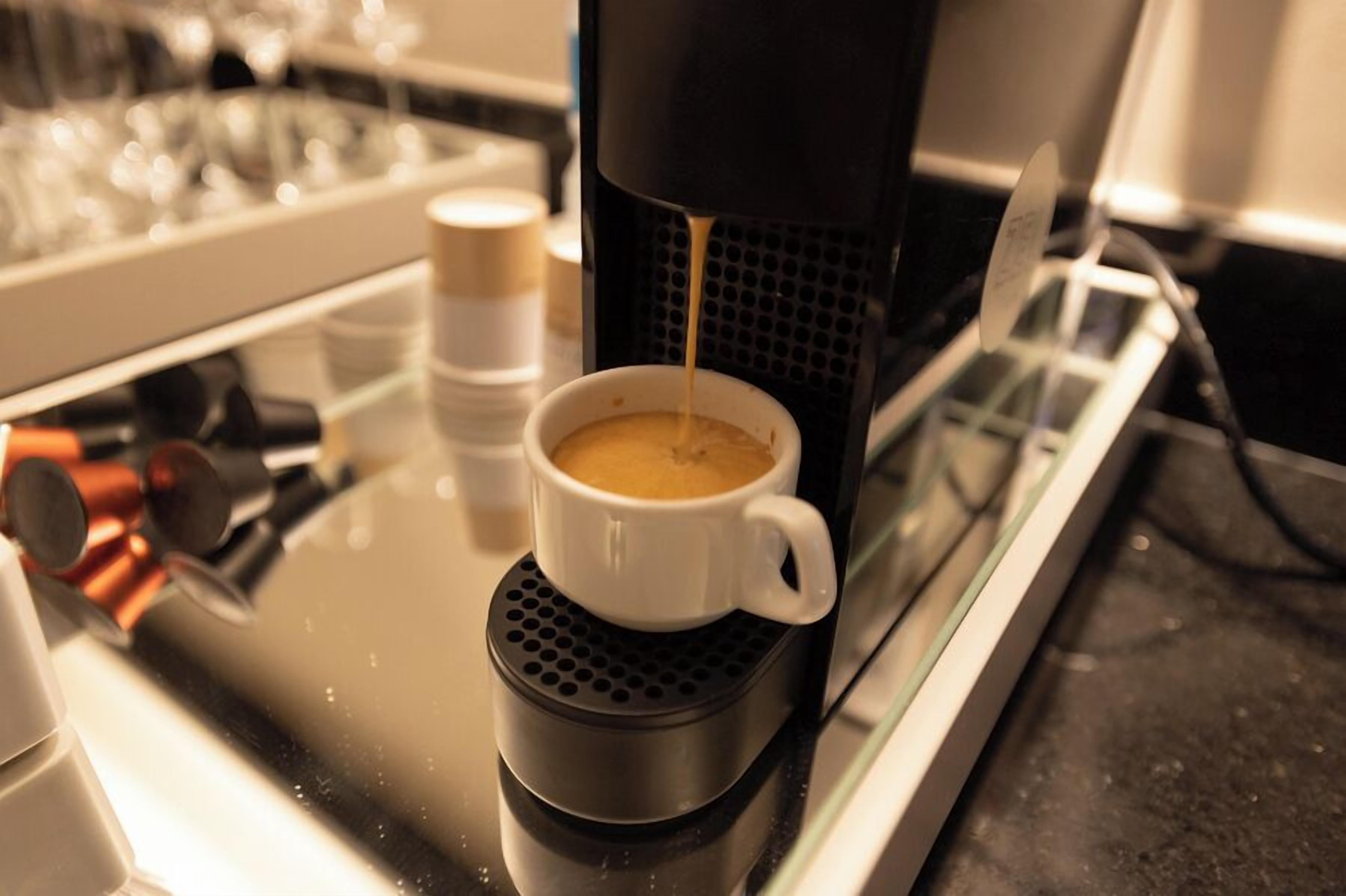 Una cafetera sirviendo café en una taza.