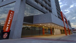 Un edificio moderno de Intercity Hotels con una entrada destacada y un gran letrero mostrando el nombre del hotel.